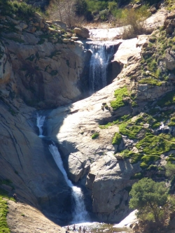People gaze up at towering falls (2 of the Three Sisters falls shown here)